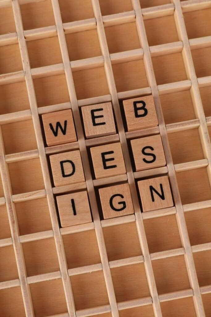 Wooden blocks spell 'WEB DESIGN' on a grid, ideal for digital themes.